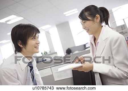 Stock Image - Office workers enjoy talking each other. Fotosearch