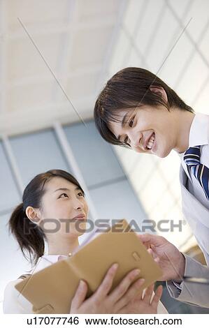 Stock Photograph - Office workers having a brief meeting. Fotosearch