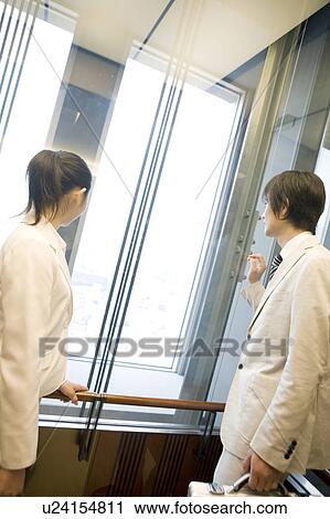 Stock Image - Office workers in an elevator. Fotosearch
