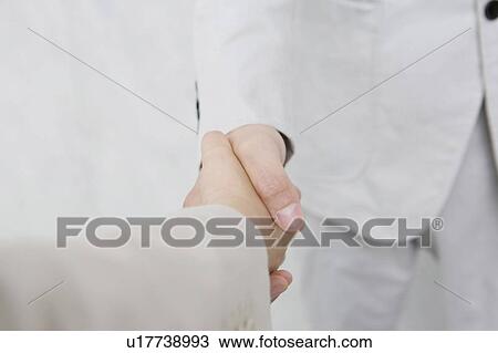 Office workers shaking hands View Large Photo Image Stock Image - Office workers shaking hands. Fotosearch