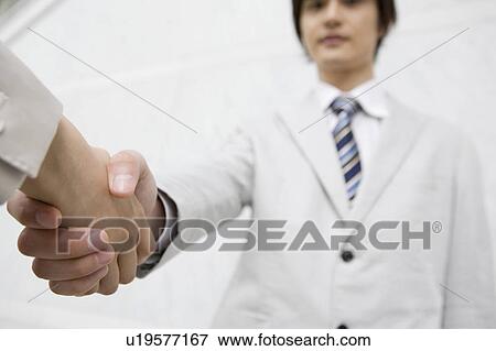 Stock Photo - Office workers shaking hands. Fotosearch