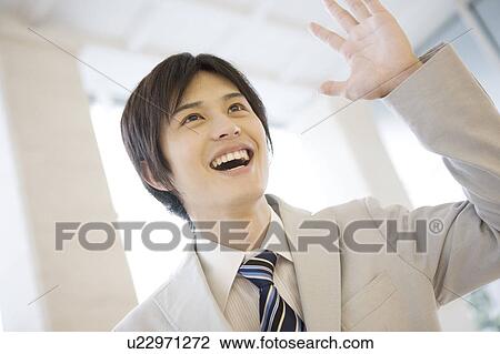 Smiling office worker waving a hand View Large Photo Image Stock Image - Smiling office worker waving a hand. Fotosearch