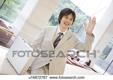 Smiling office worker waving a hand View Large Photo Image Stock Photo - Smiling office worker waving a hand. Fotosearch