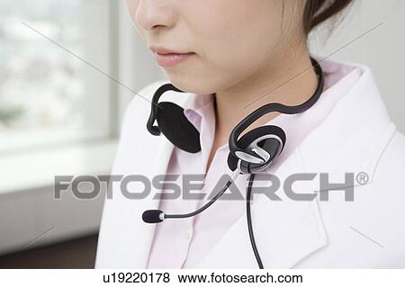 Stock Photo - Woman putting on a headset. Fotosearch