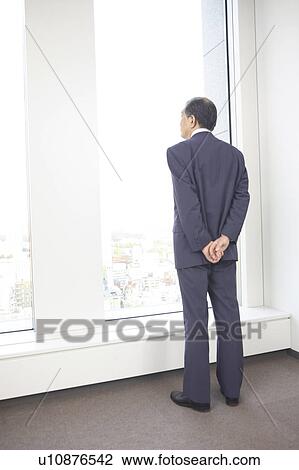 Chief executive officer looking at outside from room View Large Photo Image Stock Image - Chief executive officer looking at outside from room. Fotosearch