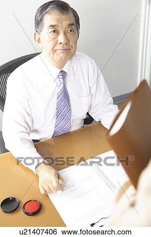 Stock Photograph - Chief executive officer pushing the stamp. Fotosearch