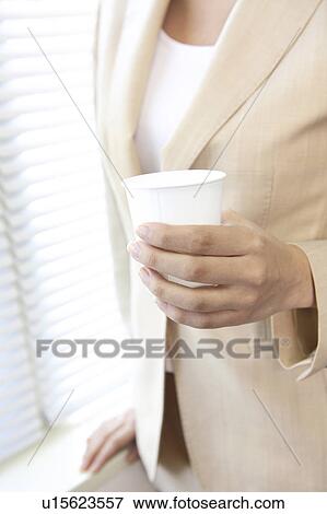 Close-up of a paper cup in a business woman's hand View Large Photo Image Stock Photo - Close-up of a paper cup in a business woman's hand. Fotosearch
