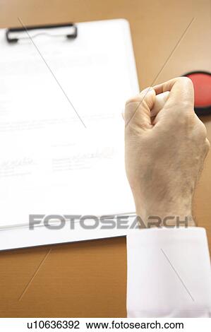 Stock Image - Hand of chief executive officer pushing the stamp. Fotosearch