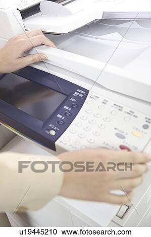 Stock Image - Hand of Japanese office lady taking a copy. Fotosearch