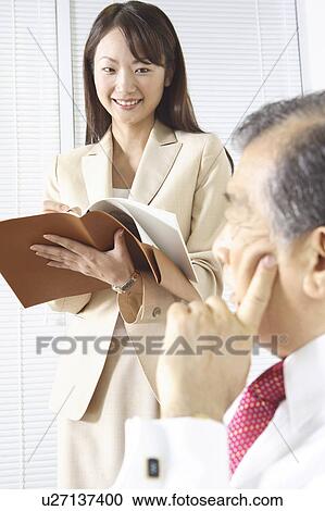 Stock Image - Japanese office lady taking a memo. Fotosearch
