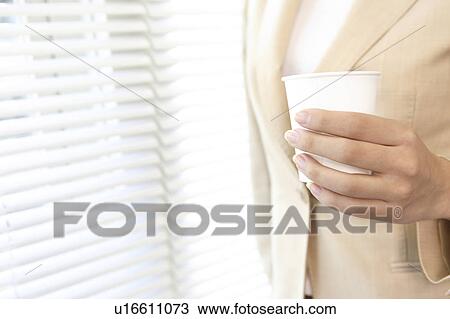Stock Image - Office lady having a paper cup. Fotosearch