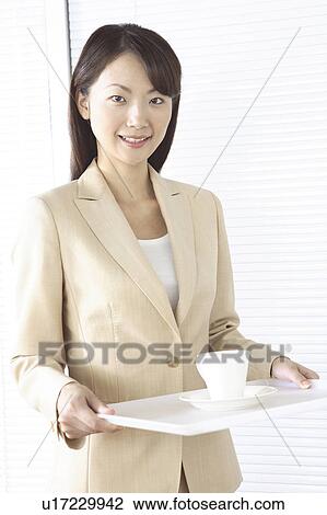 Stock Image - Office lady serving a coffee. Fotosearch