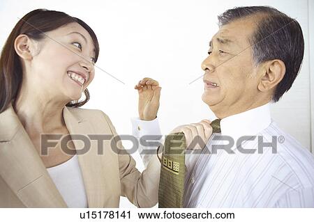 Stock Image - Secretary grabbing a tie of the president. Fotosearch