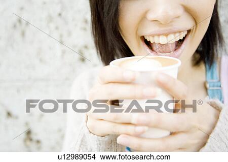 Picture - Lips of a woman drinking Cafee latte. Fotosearch