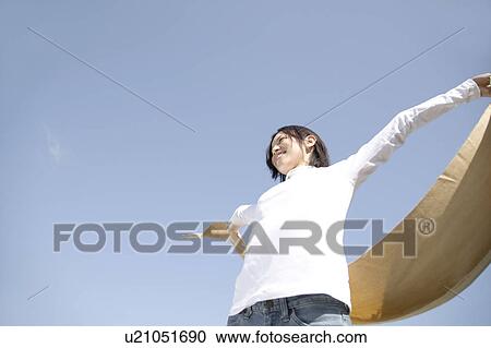 Stock Image - Woman below the blue sky. Fotosearch