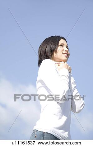 Stock Photo - Woman below the blue sky. Fotosearch