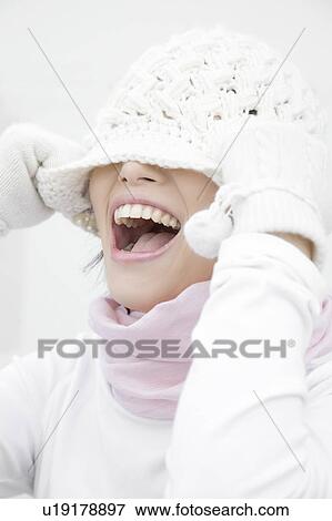 Stock Photo - Woman covering the face with a knit hat. Fotosearch