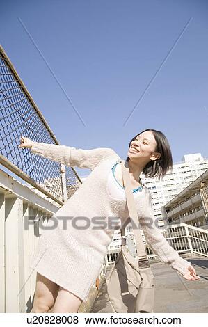 Stock Photo - Woman gripping a fence. Fotosearch