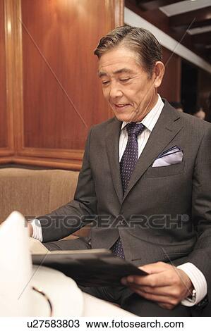 Executive looking at a menu View Large Photo Image Stock Image - Executive looking at a menu. Fotosearch