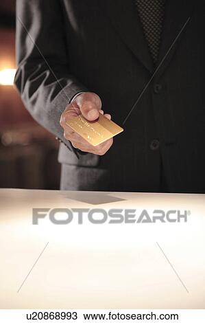Stock Image - Japanese executive checking by credit card. Fotosearch