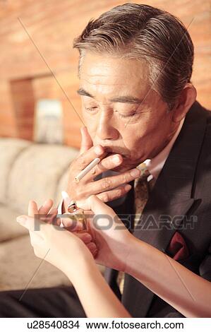 Picture - Japanese executive smoking a tobacco. Fotosearch