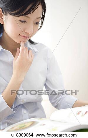 Picture - Japanese woman reading a magazine. Fotosearch