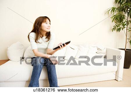 Stock Photograph - Japanese woman watching a TV. Fotosearch
