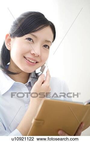 Stock Image - Woman with a planner and a phone. Fotosearch