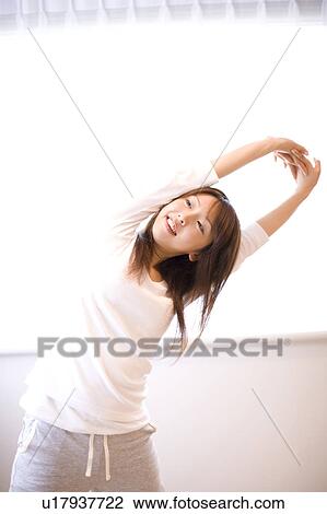 Stock Image - Young woman stretching. Fotosearch