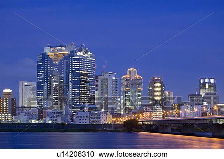 Stock Image - Evening view of city from water. Fotosearch