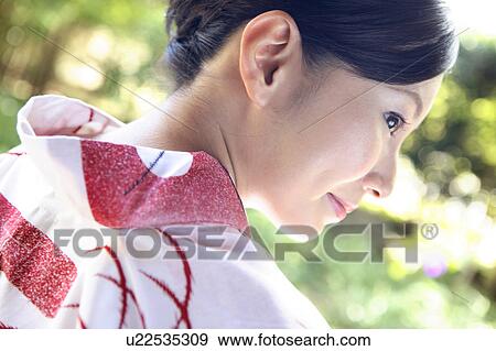 Stock Photo - Back figure of Japanese woman putting on a yukata. Fotosearch