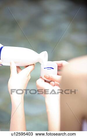 Stock Image - Hand of woman pouring a Japanese sake. Fotosearch