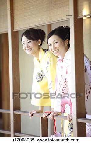Stock Photography - Japanese woman looking at outside from corridor. Fotosearch