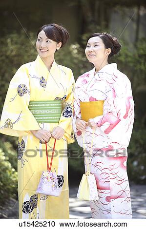 Stock Image - Japanese woman putting on a yukata. Fotosearch