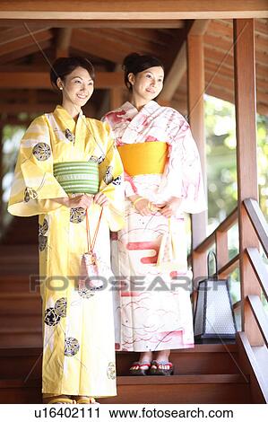Stock Image - Japanese woman putting on a yukata. Fotosearch