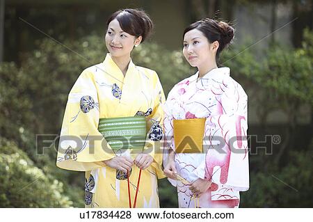 Stock Photo - Japanese woman putting on a yukata. Fotosearch