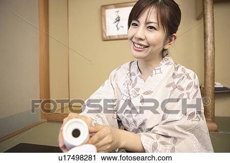Japanese woman putting on kimono View Large Photo Image Stock Image - Japanese woman putting on kimono. Fotosearch