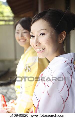 Stock Image - Japanese women putting on a yukata. Fotosearch
