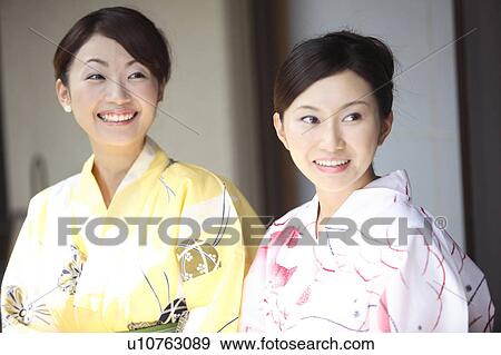 Stock Photo - Japanese women putting on a yukata. Fotosearch