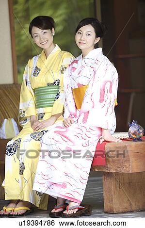 Stock Photograph - Japanese women putting on a yukata. Fotosearch