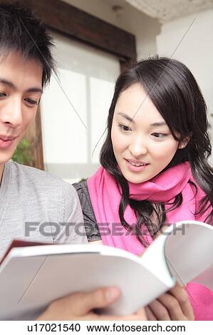 Stock Image - Japanese couple reading a book. Fotosearch