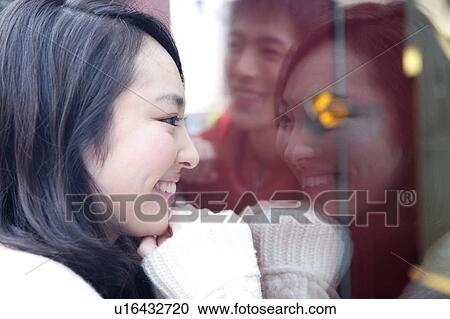 Stock Image - Japanese couple reflected in a window. Fotosearch