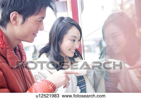 Stock Image - Japanese young couple enjoy window shopping. Fotosearch