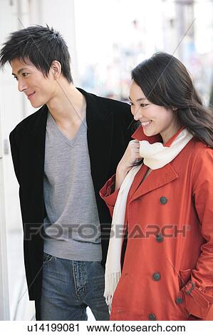 Stock Image - Japanese young couple enjoy window shopping. Fotosearch