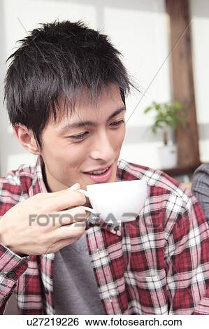 Stock Photograph - Japanese young man drinking coffee. Fotosearch