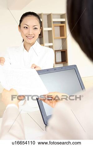 Stock Image - Office lady handing a document. Fotosearch