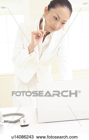 Stock Image - Office lady looking at PC monitor. Fotosearch