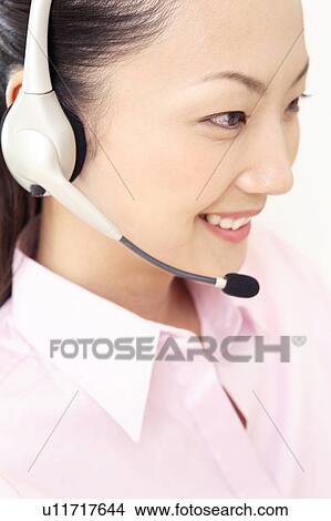 Picture - Office lady talking with headset. Fotosearch