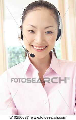 Stock Photo - Office lady talking with headset. Fotosearch
