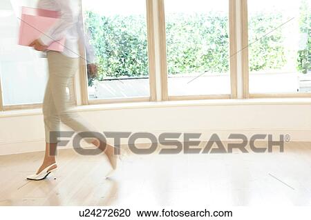 Stock Image - Office lady walking in a room. Fotosearch